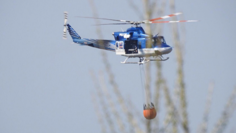 U Bělčic hoří pole a les, hasiči přivolali na pomoc vrtulník s bambivakem