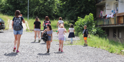 Usměvavé děti v kontrastu s šedí, která je všude okolo. To jsou děti z ubytoven