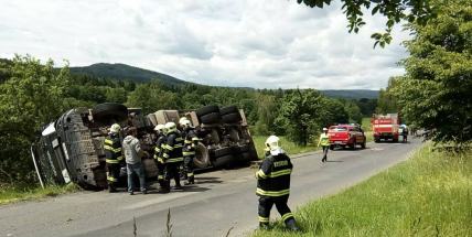 Po nehodě skončil nákladní vůz s kompostem převrácený na boku
